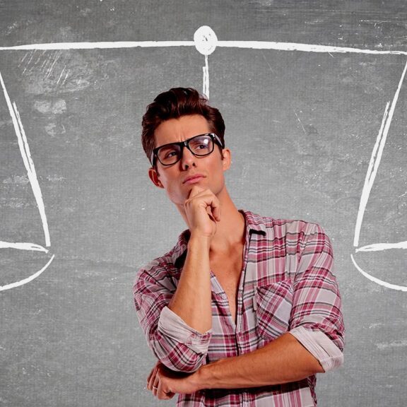 Man contemplating scales of justice on chalkboard