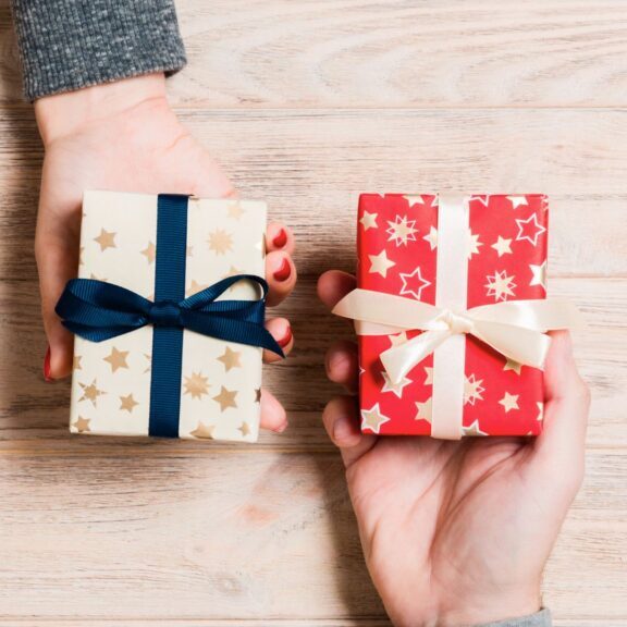 Elegant gift boxes with satin ribbons on a wooden table, showcasing luxurious packaging options for skincare, supplements, or health products by Structure Formulations.
